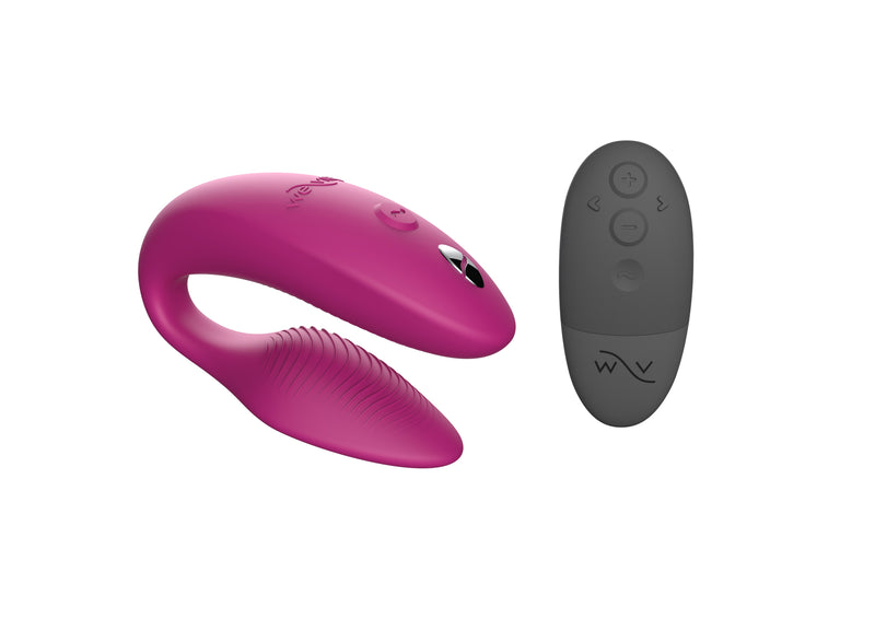 We-Vibe Sync in pink: C-shaped couples vibrator with a ribbed inner arm, shown with its gray remote