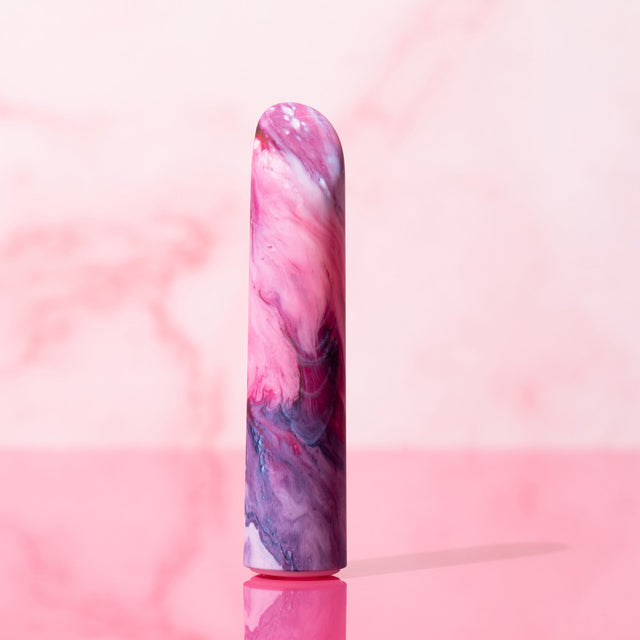 Blush Limited Addiction Entangle: pink and purple marbled bullet vibrator with an angled tip, standing on pink marble