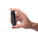 Black metallic Bang! bullet held between thumb and fingers to show its small size
