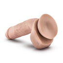 Beige Anthony dildo lying on its side, showing the suction cup base