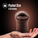 Pocket size: Krystal vibrating stroker held on an open palm, 5.25 inches