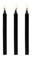 Three black Fire Sticks candles standing upright and lit