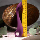 Purple Lochness standing beside a ruler, about 7 in long