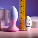 Paradise Plug standing beside a ruler and its remote, about 4 in tall
