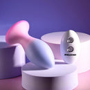 Paradise Plug lying at an angle beside its remote, showing the flared pink base