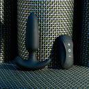 Black Beauty plug standing on its curved base next to the remote with plus, power and minus buttons