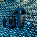 Black Beauty plug charging with its USB cable, next to the remote with its battery compartment open