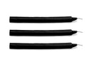 Three slim black Fire Sticks wax play candles laid flat, wicks to the right