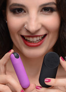 Model holding the purple Bang! bullet and its black wireless remote to show their size