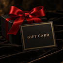 Black gift card with gold foil lettering in front of a black gift box tied with a crimson satin bow